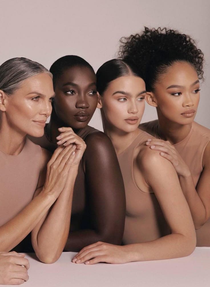 Four women of different ages and skin tones photographed together